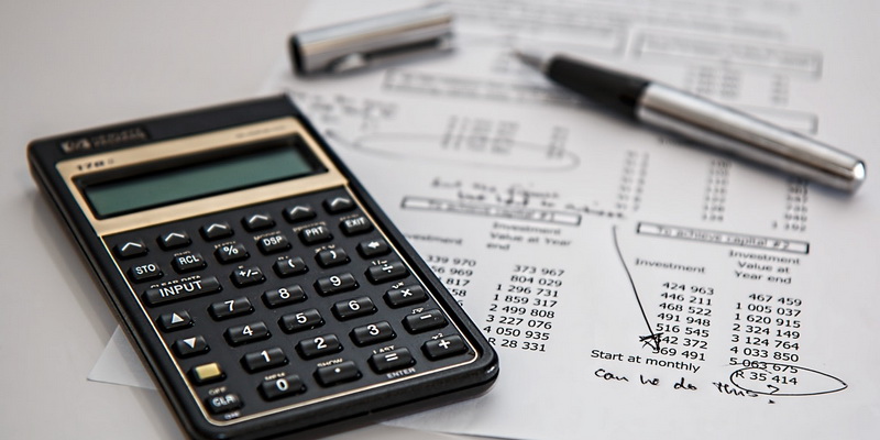 calculator, pen and sheet with bills